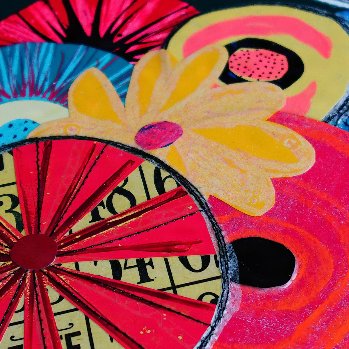 A close-up of a colorful abstract floral artwork with overlapping circular and petal-like shapes in red, pink, yellow, blue, black, and cream tones.