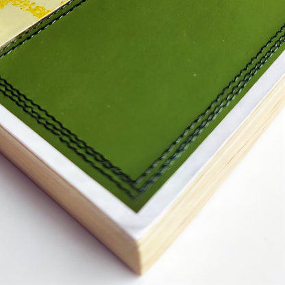 Close-up view of machine stitching along edge of wood panel