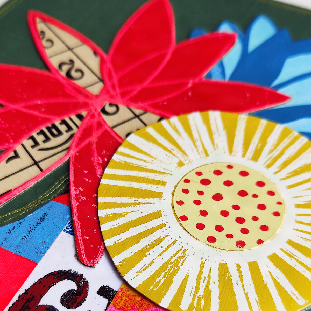 A close-up of a colorful abstract floral or petal-shaped artwork with layered red, yellow, blue.