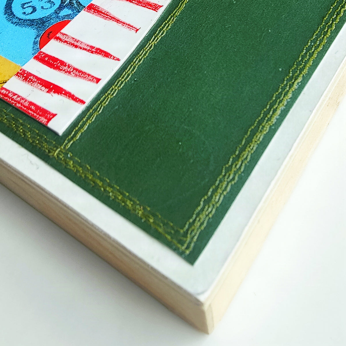 Close up of machine stitching along edge of wood panel