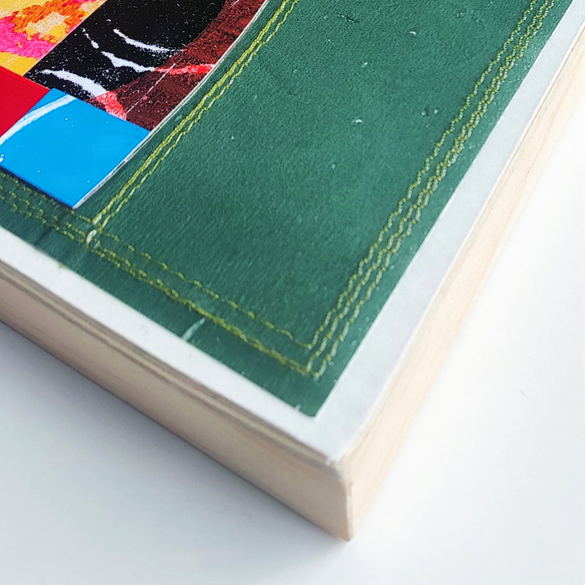 Close-up of machine stitching along edge of wood artwork panel
