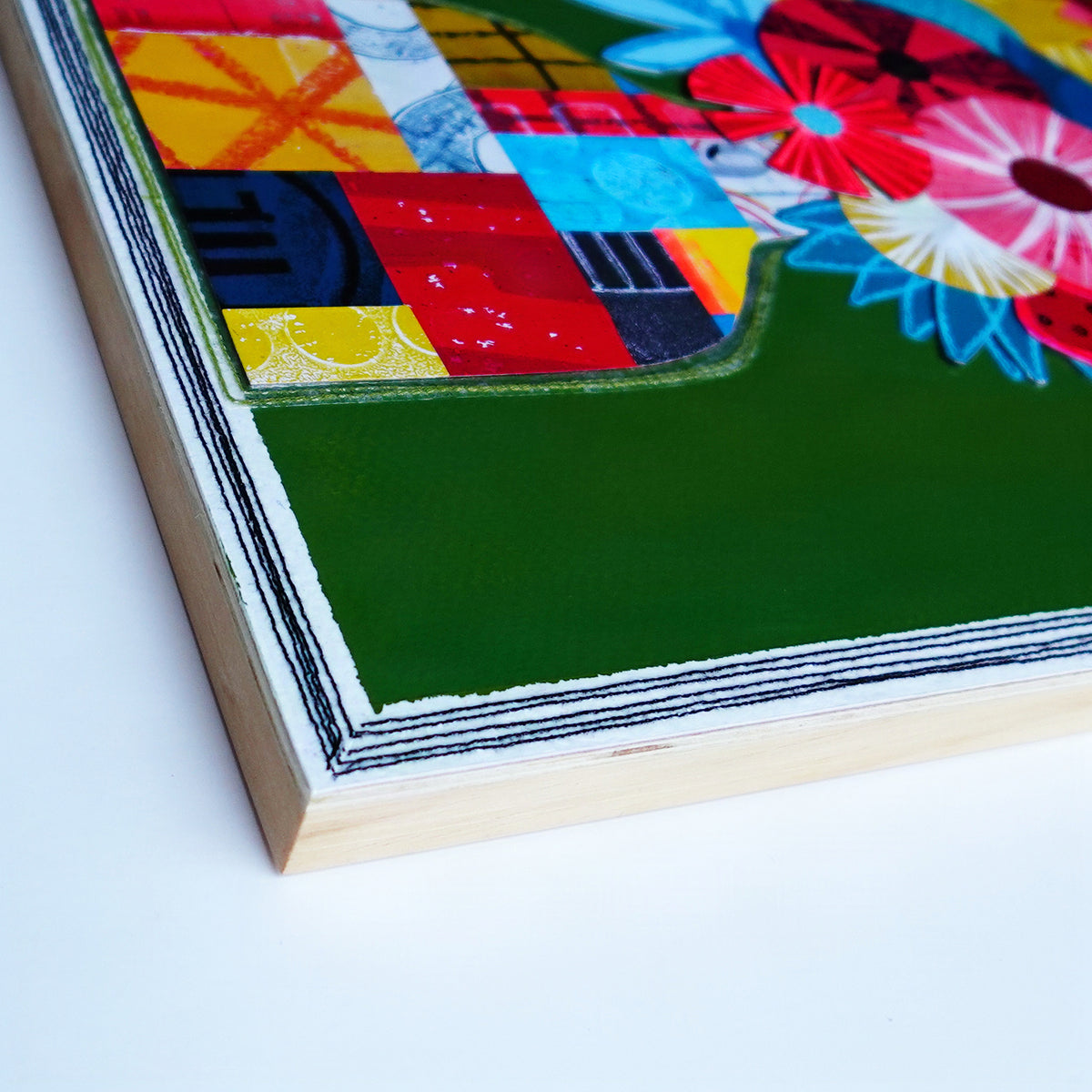Close up image of wood panel edge with black stitching detail